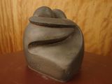 a stone sculpture sitting on a table in front of a wooden wall