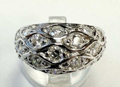 a close up of a ring with diamonds on a white surface
