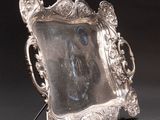 an antique silver picture frame with a picture of a woman on it