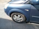 a small blue car parked on the side of the road