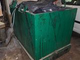 une boîte verte dans un garage, avec une voiture en arrière-plan