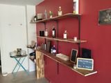 a red wall with shelves and a laptop on it