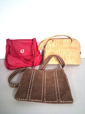 several purses are lined up on a table with a white background