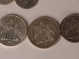 a close up of a number of coins on a white surface