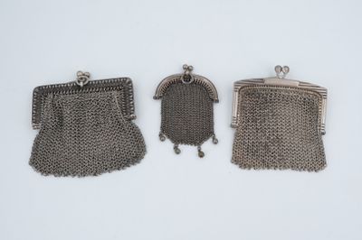 trois porte-monnaie en métal argenté posés sur une surface blanche