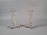 pair of clear glass candlesticks on a white background