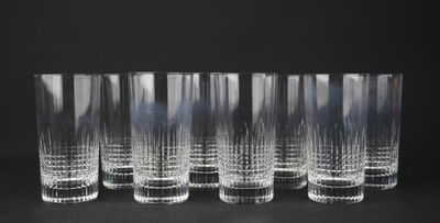 six clear glasses are lined up in a row on a black surface