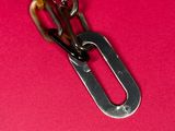 a close up of a metal chain on a pink surface