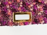a close up of the label on a purple and pink tweeded bag