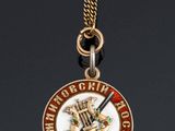 a close up of a medal on a chain on a black surface