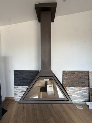 a fireplace in the middle of a living room with a wood floor