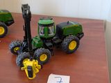 deux tracteurs miniatures posés sur une table, avec un chiffre inscrit sur la table