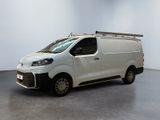 La camionnette blanche est garée dans une pièce blanche au plafond noir.