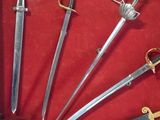 a lot of swords in a display case on the table