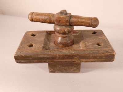 un petit objet en bois muni d'un manche en bois