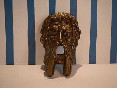 a gold statue of a man with a beard on a table