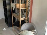 a picture of a room with a chair and a book shelf