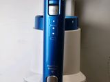a blue electric toothbrush sitting on top of a blender
