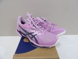purple asics running shoes on a cardboard box on a table