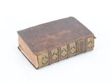 an old book sitting on top of a table on a white surface