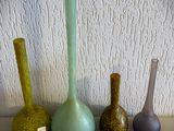 quatre vases de couleurs différentes posés sur une table