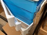 a blue and white cooler sitting on a pallet next to boxes
