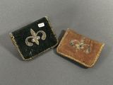 pair of small purses with embroidered designs on them sitting on a table