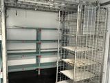 a metal cage with shelves and shelves in a room
