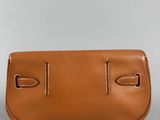 a tan leather purse with two handles and a strap