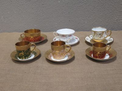 cinq tasses et soucoupes posées sur une table