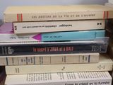 many books stacked on top of each other on a table