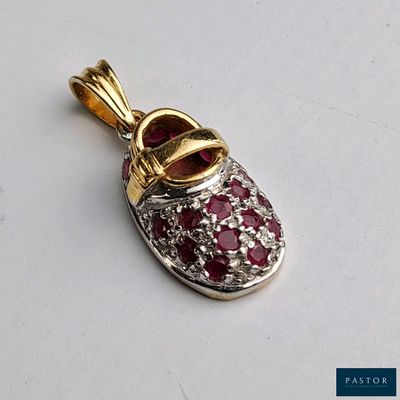 une photo d'un pendentif en forme de chaussure en losange rouge et blanc posé sur une surface blanche
