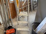 a room with a ladder and a bucket of tools in it