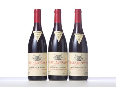 three bottles of red wine sitting on top of a table