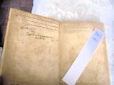 an old book with a piece of paper on top of it