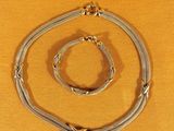 a close up of a necklace and bracelet on a yellow surface