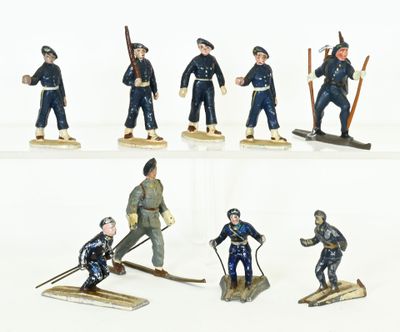 six figurines of men in uniforms with skis and poles