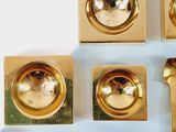 a lot of gold colored metal objects on a white surface
