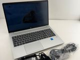 an open laptop computer sitting on top of a table next to a charger