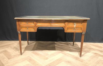a wooden desk with marble top on a chevroned wood floor