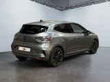 the rear end of a silver car in a white room