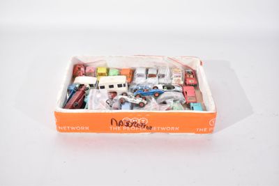 une boîte contenant un assortiment de jouets, posée sur une surface blanche