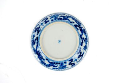 une assiette bleue et blanche posée sur un fond blanc