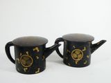 two black and gold teapots with gold designs on them