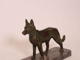 statue of a dog on a marble base on a white background