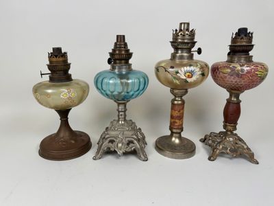 several different colored glass lamps are lined up on a white surface
