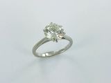 a close up of a diamond ring on a white surface
