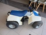 a white and blue atv with a blue seat on the floor