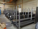 rows of steel bars in a warehouse with a car parked in front of them