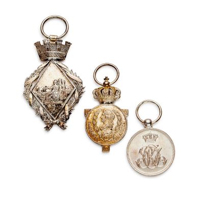deux médailles d'argent et d'or ainsi qu'une pièce de monnaie sur fond blanc